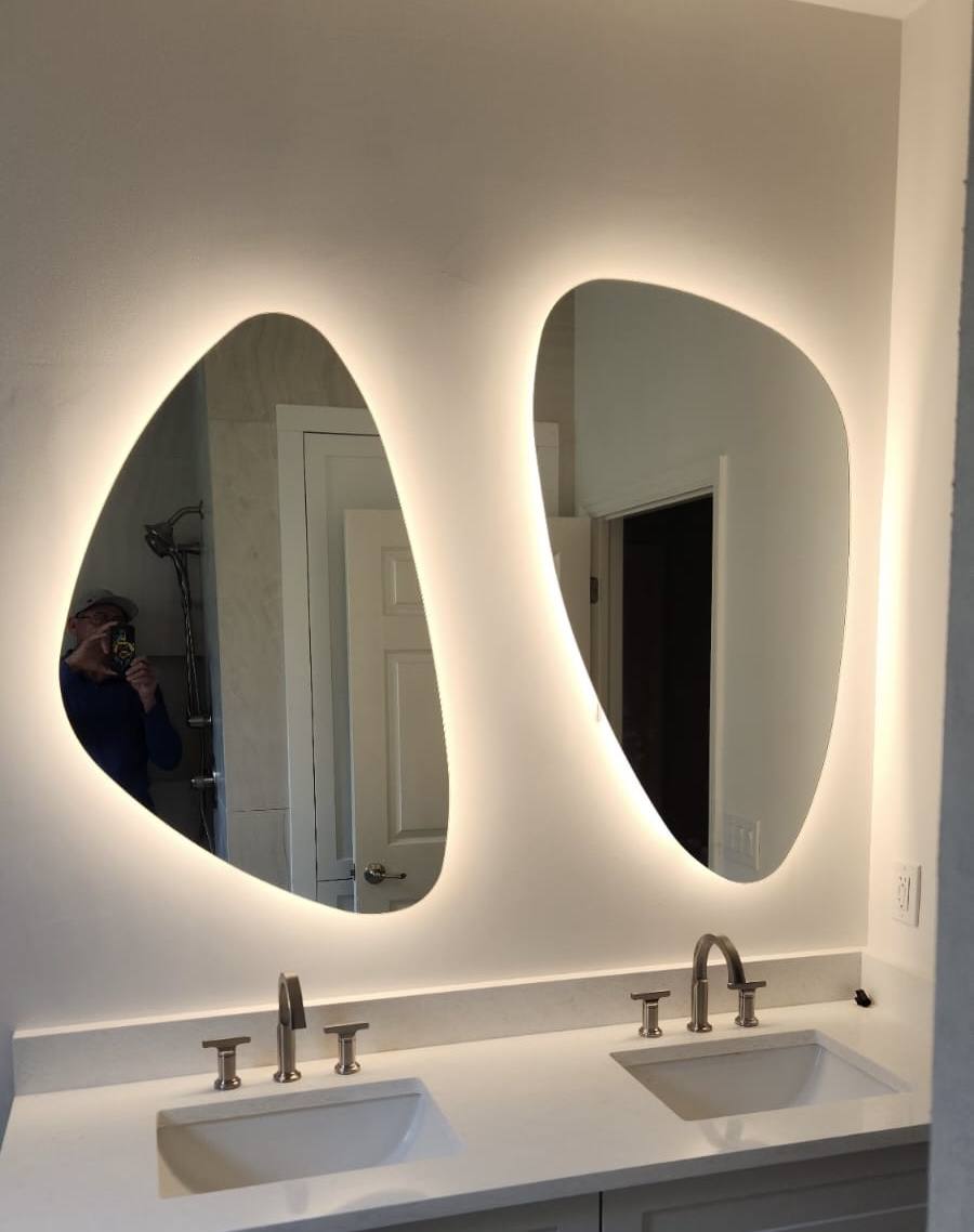 Finished bathroom remodel with backlit mirrors